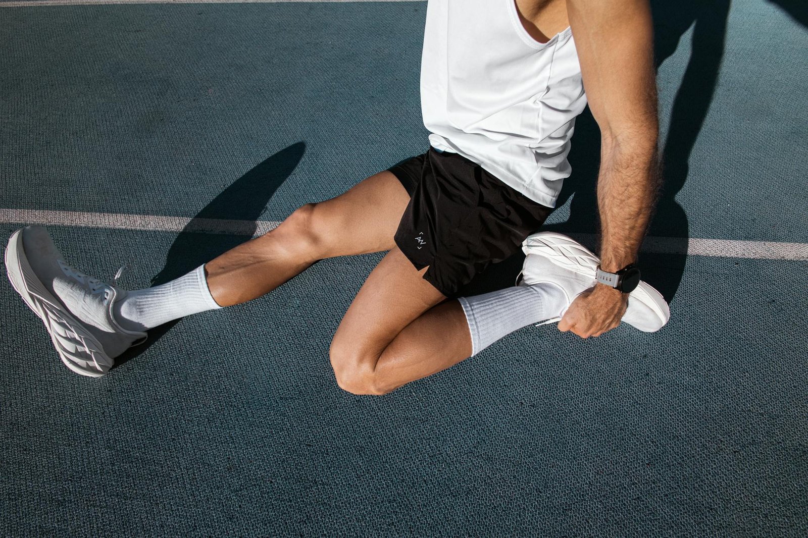 athlete stretching on outdoor track surface