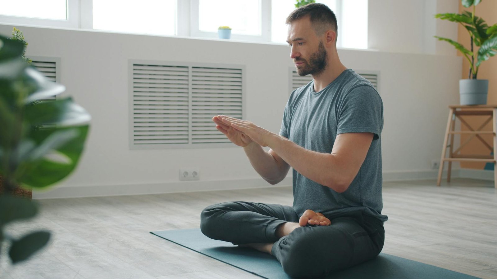 man practicing yoga and meditation indoors